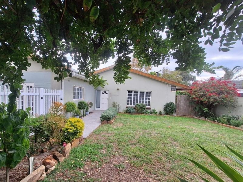 A well-maintained front garden featuring a paved walkway leading to the entrance, complemented by established landscaping and secure perimeter fencing.