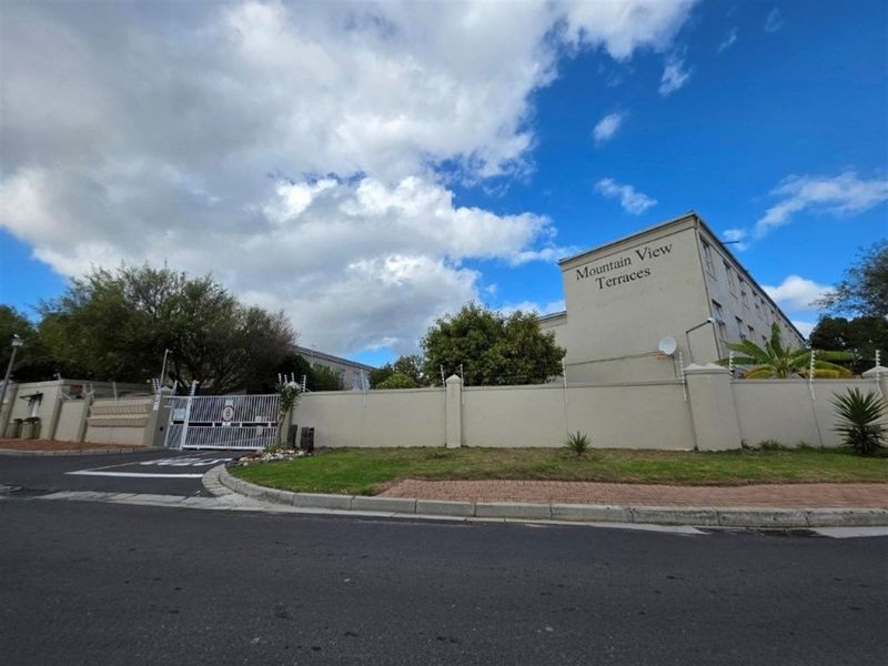 Street view of the Mountain View Terraces apartment complex, featuring a secure perimeter wall, electric fencing, and gated entrance.