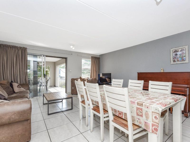 Open-plan living and dining area featuring tiled flooring and a sliding glass door providing access to the patio.
