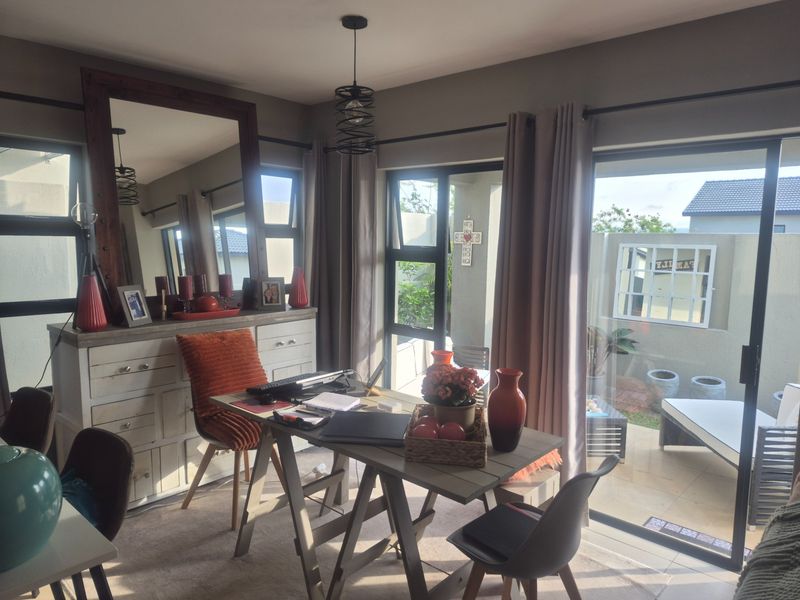 A bright living area featuring large sliding glass doors that provide natural light and direct access to the outdoor patio space.