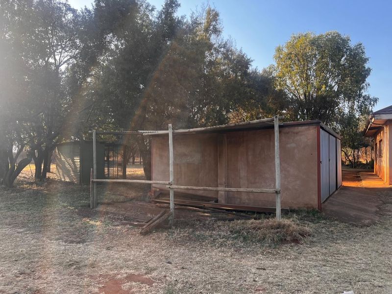 A basic utility shed and timber-framed structure located on the residential property grounds.