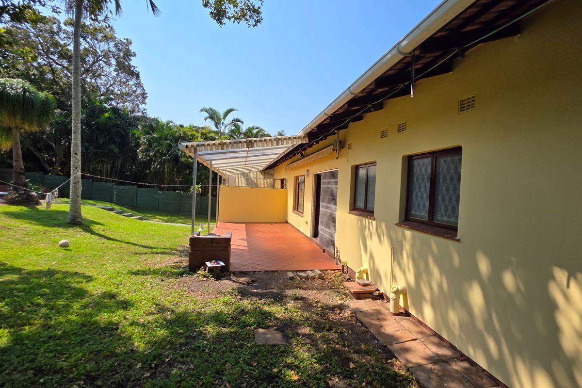 Rear view of the property featuring a covered patio area, tiled flooring, and access to the garden and pool area.