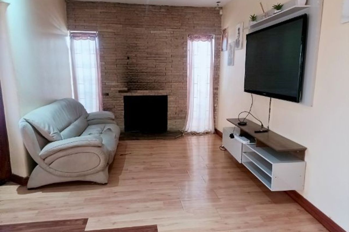 Living room featuring a stone accent wall with a fireplace, laminate flooring, and recessed lighting.