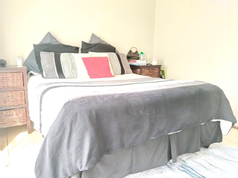 A bedroom featuring tiled flooring and neutral wall finishes, providing a functional space for rest.