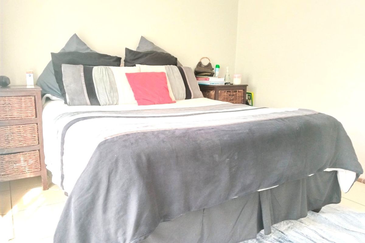 A bedroom featuring tiled flooring and neutral wall finishes, providing a functional space for rest.