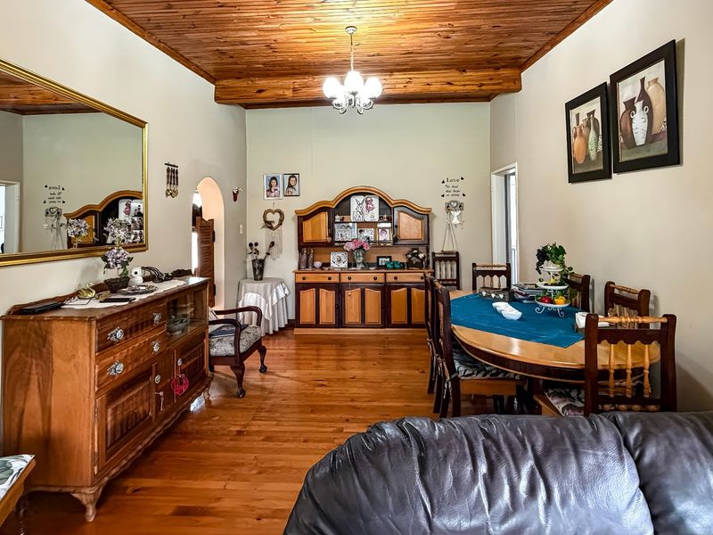 A dining room featuring warm timber flooring and a matching timber-paneled ceiling, creating a traditional and inviting atmosphere.