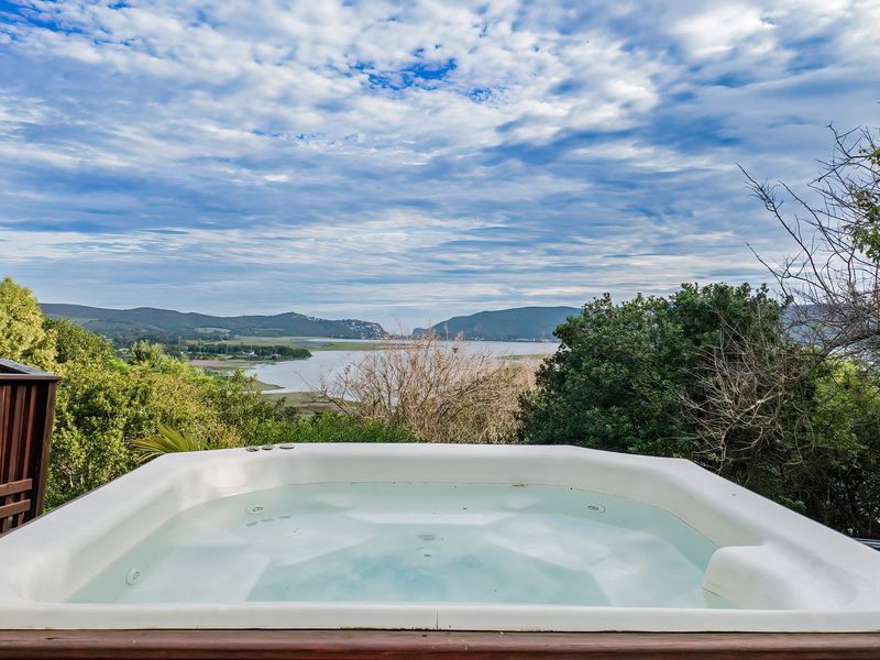 Outdoor timber deck featuring a built-in hot tub with expansive scenic views of the surrounding landscape and water.
