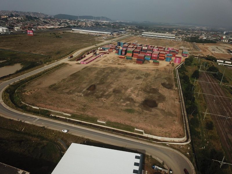 Aerial view of a large industrial land parcel featuring perimeter fencing, adjacent road access, and proximity to railway infrastructure.