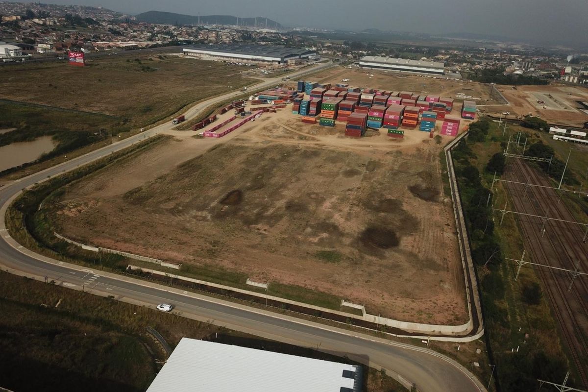 Aerial view of a large industrial land parcel featuring perimeter fencing, adjacent road access, and proximity to railway infrastructure.