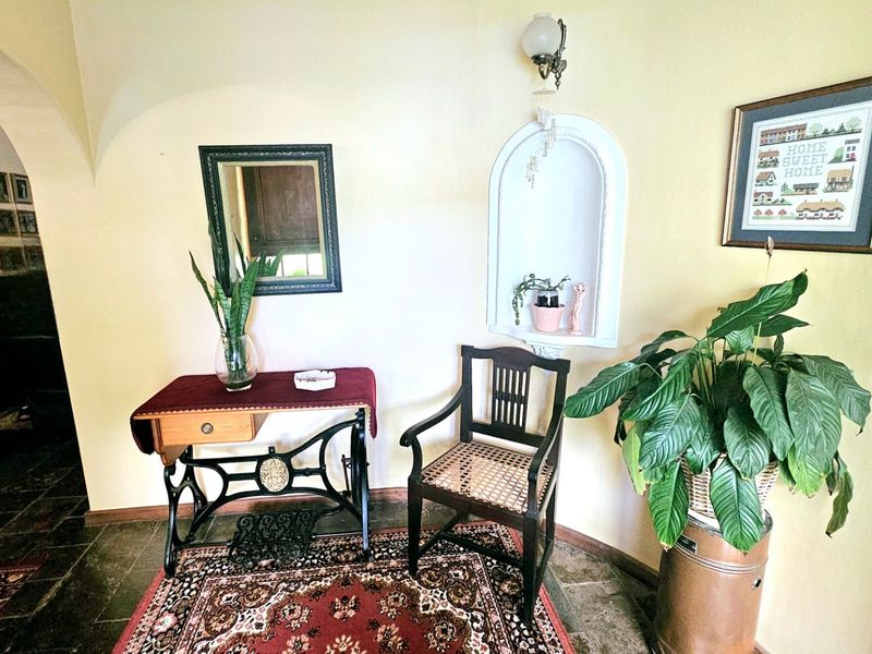 An inviting entryway featuring classic stone flooring, a decorative arched wall niche, and warm lighting, creating a welcoming transition into the home.