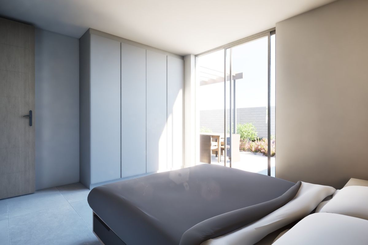 Modern bedroom featuring built-in cupboards, tiled flooring, and large sliding glass doors providing direct access to an outdoor patio area.