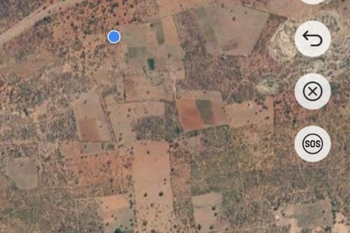 An aerial satellite view of a large rural farm property showing various plots of land and natural terrain.