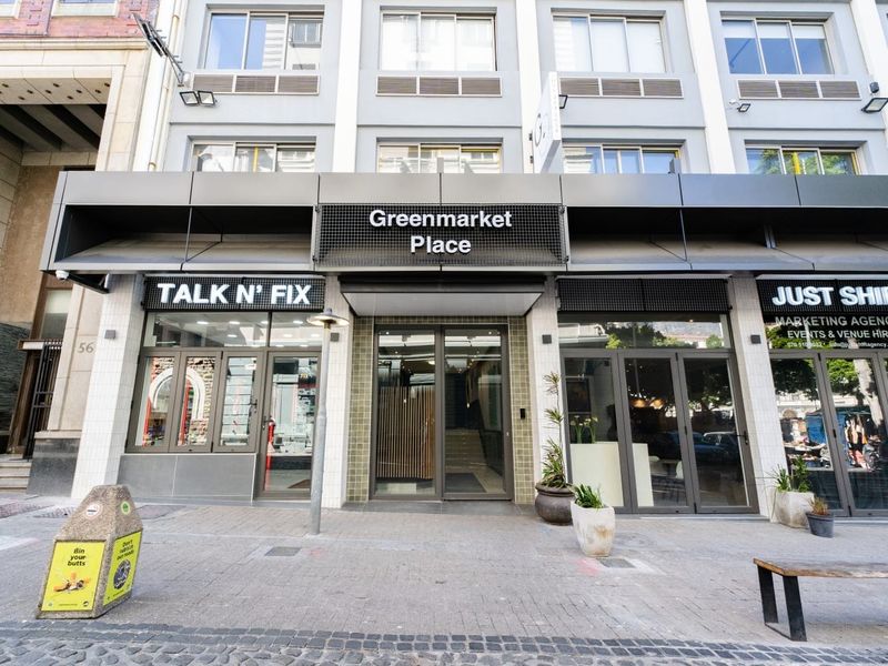 Street-level view of the Greenmarket Place building entrance, featuring modern glass storefronts and professional signage in a busy urban setting.