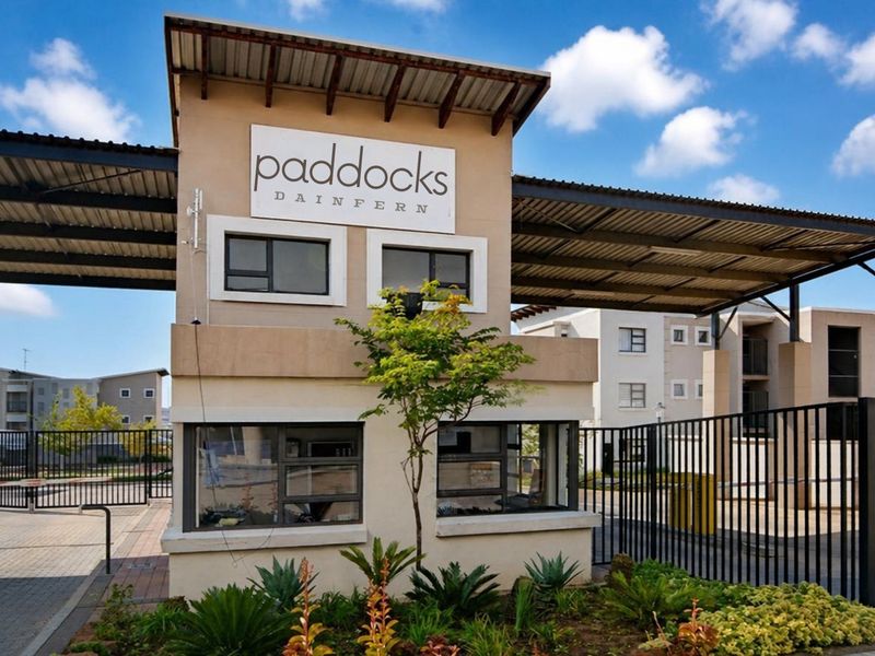 The main security entrance and gatehouse for the Paddocks Dainfern apartment complex, featuring modern architectural design and landscaped surroundings.