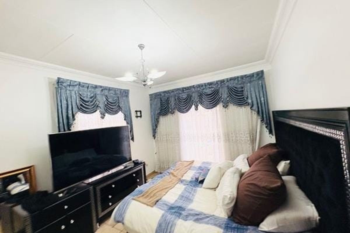 A bedroom featuring decorative ceiling cornicing and a central chandelier, providing a classic foundation for interior updates.