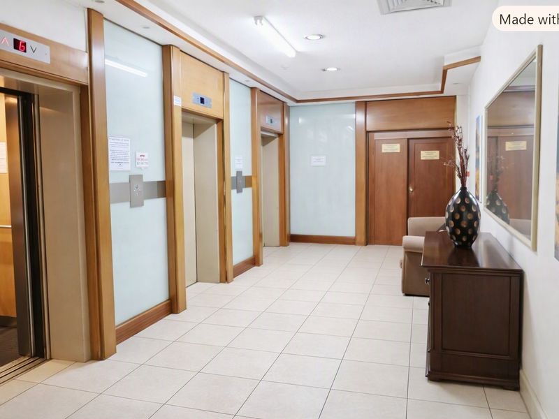 A well-maintained retirement village elevator lobby featuring tiled flooring, timber accents, and modern glass wall paneling.