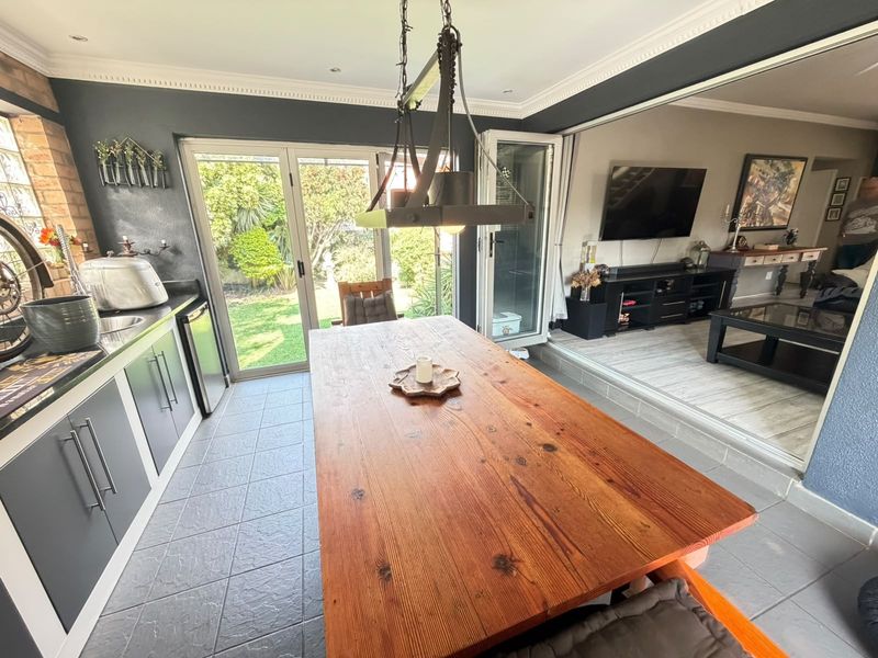 Open-plan living and dining area featuring tiled floors, modern cabinetry, and bi-fold doors providing seamless access to the rear garden.