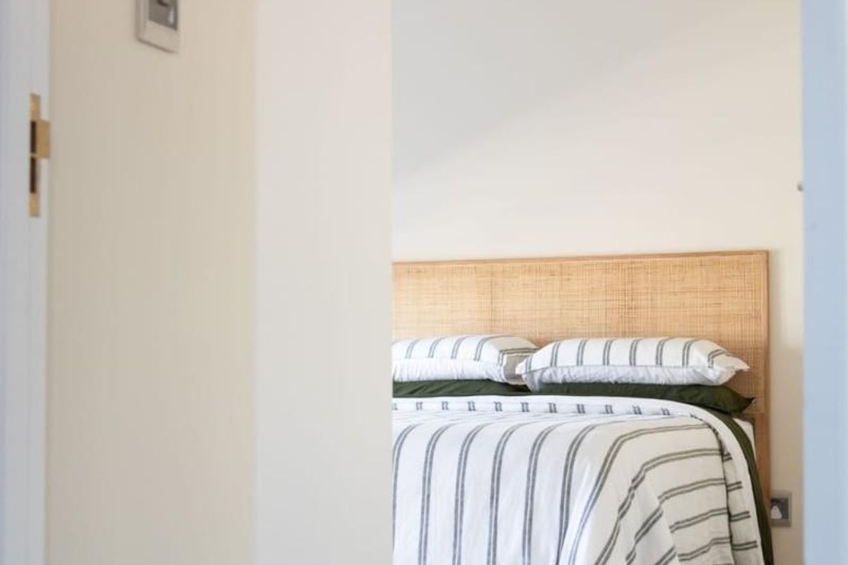 A view into a bright, modern bedroom featuring neutral tones, tiled flooring, and a clean, minimalist aesthetic.