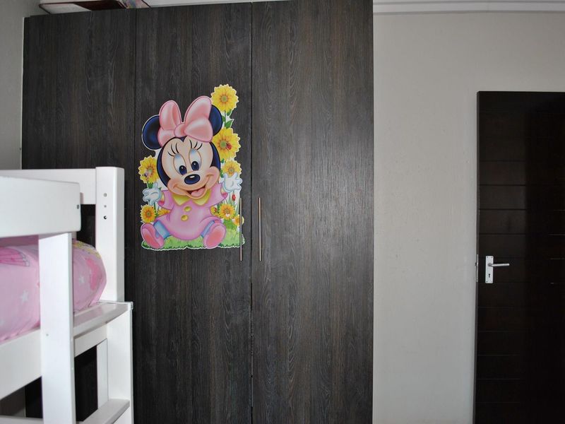 A bedroom featuring a dark wood-finish built-in wardrobe and a matching internal door.