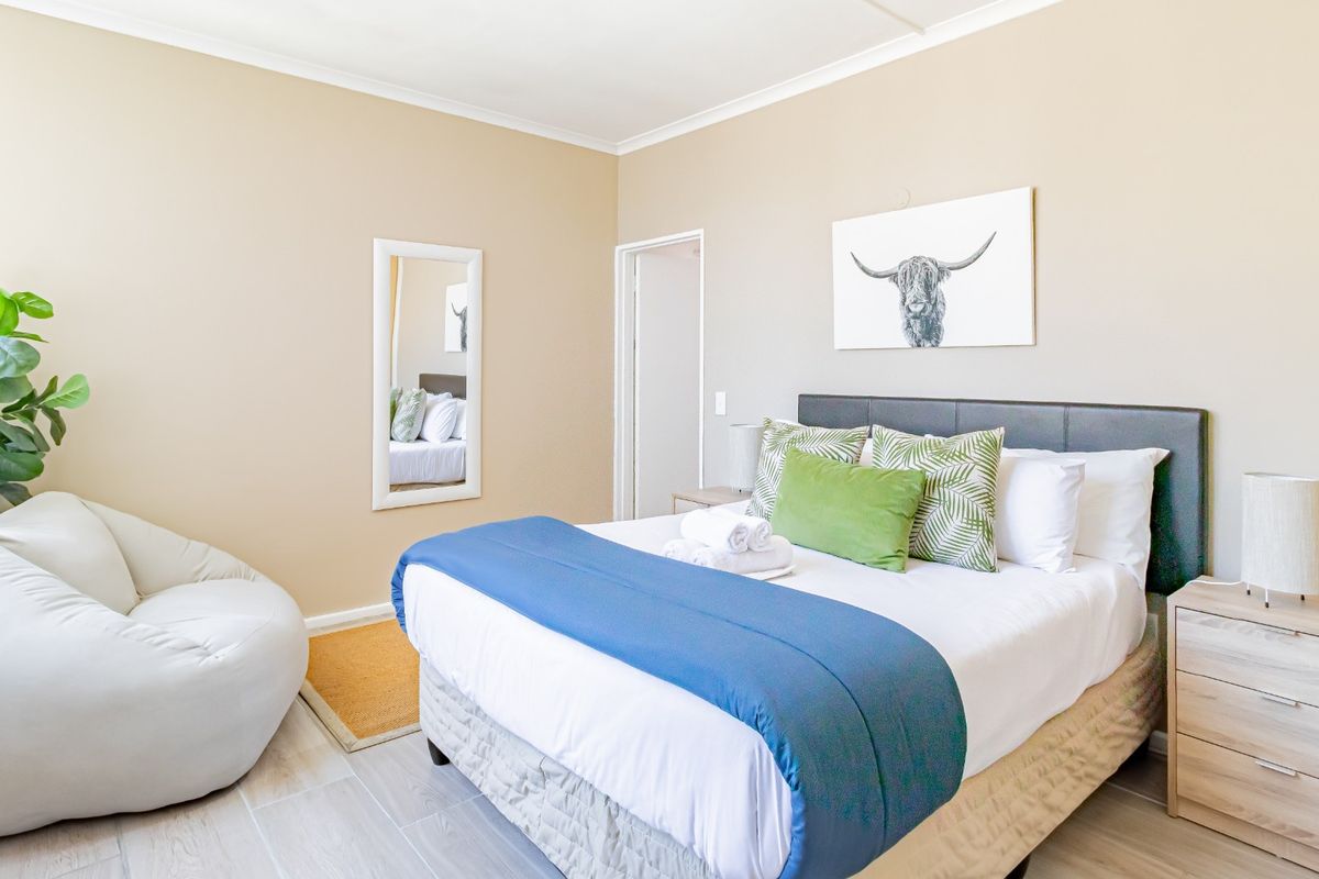 A well-maintained bedroom featuring neutral wall tones, tiled flooring, and coved ceiling details, providing a clean and comfortable living space.