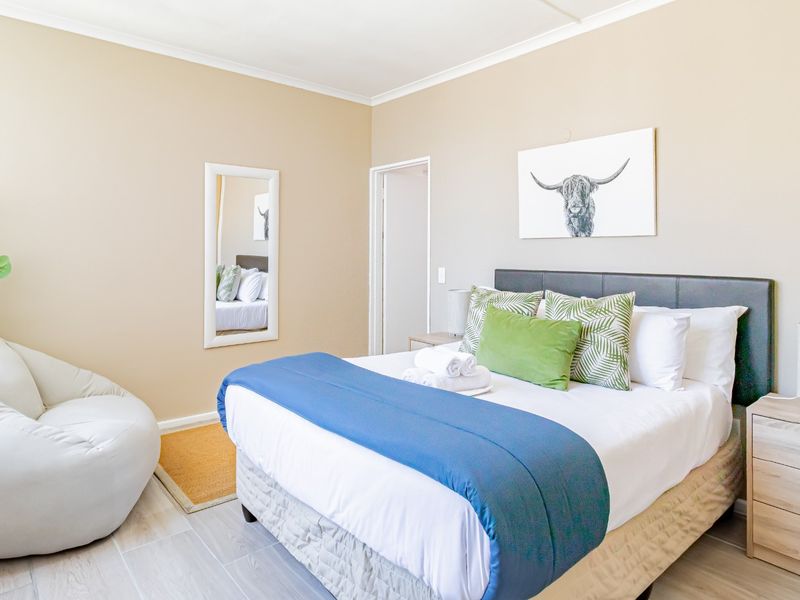 A well-maintained bedroom featuring neutral wall tones, tiled flooring, and coved ceiling details, providing a clean and comfortable living space.
