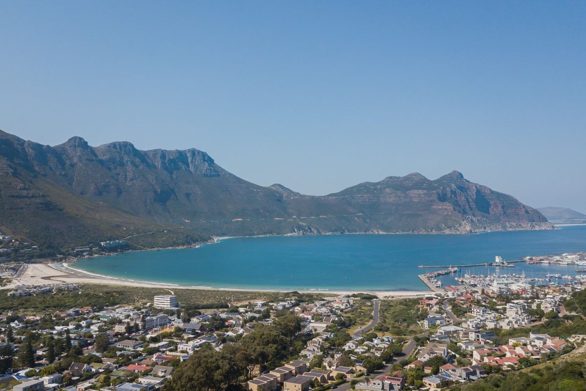 An expansive aerial view of the coastal landscape, featuring the bay, surrounding mountains, and the residential neighborhood.