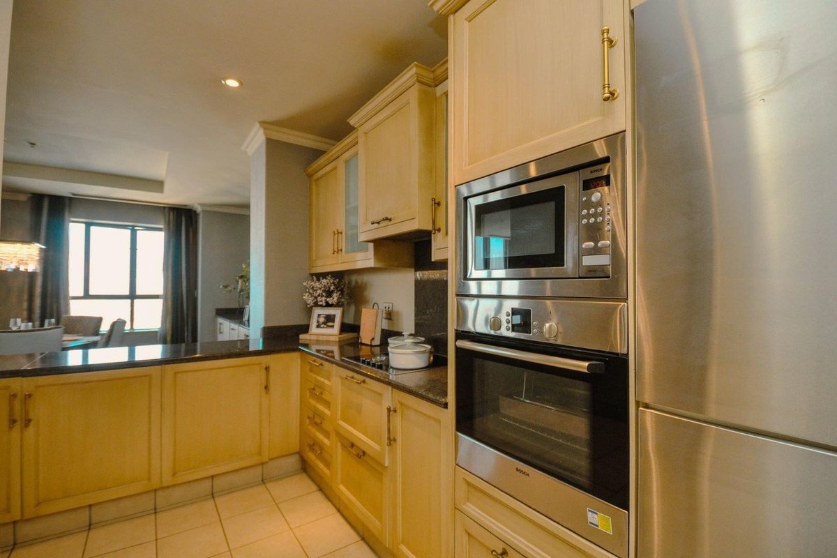A well-appointed kitchen featuring light wood cabinetry, granite countertops, and integrated stainless steel appliances including an oven and microwave.