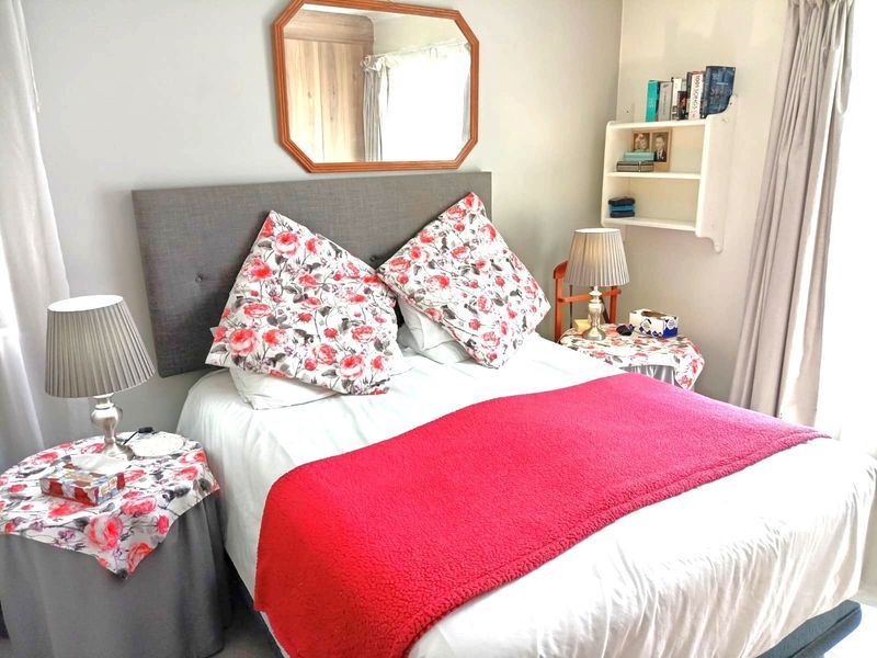 A cozy bedroom featuring neutral wall tones and built-in wall shelving, providing a functional and comfortable sleeping space.