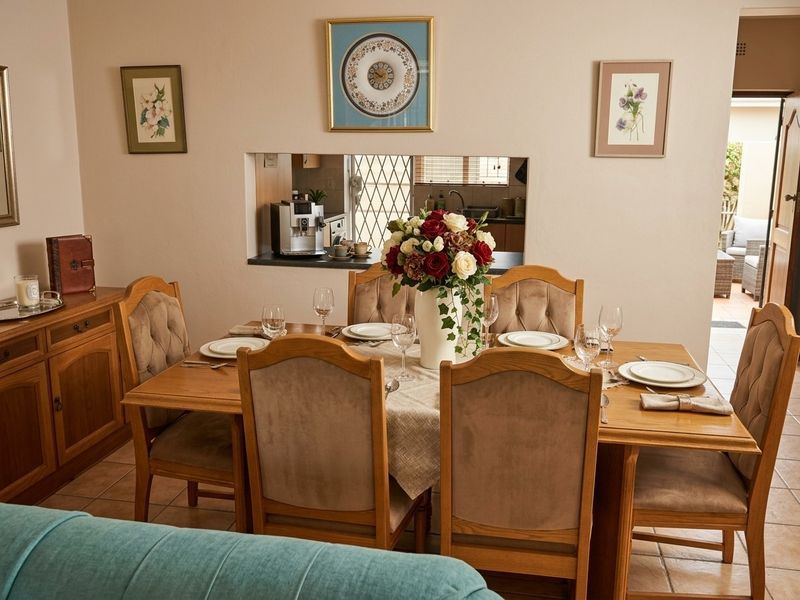 A dining room featuring tiled flooring and a convenient serving hatch connecting to the kitchen area.