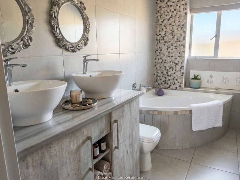 Modern bathroom featuring a double vanity with vessel sinks, a corner bathtub, and contemporary tiled finishes.