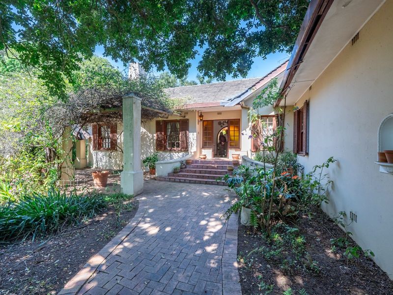 Charming front entrance featuring a brick paved walkway, covered pergola, and classic timber shutters leading to a welcoming elevated porch.