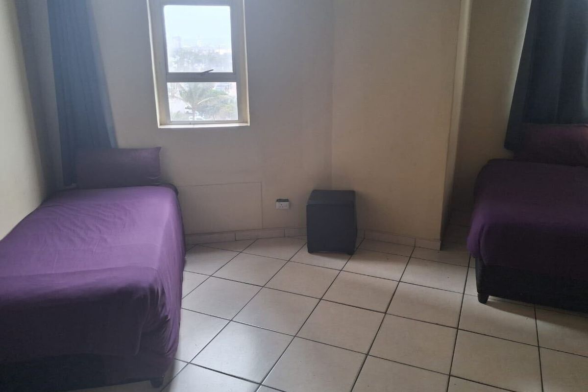 A bedroom featuring tiled flooring and a window with natural light.