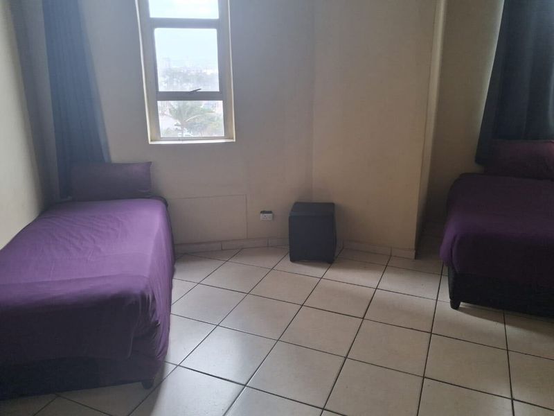 A bedroom featuring tiled flooring and a window with natural light.