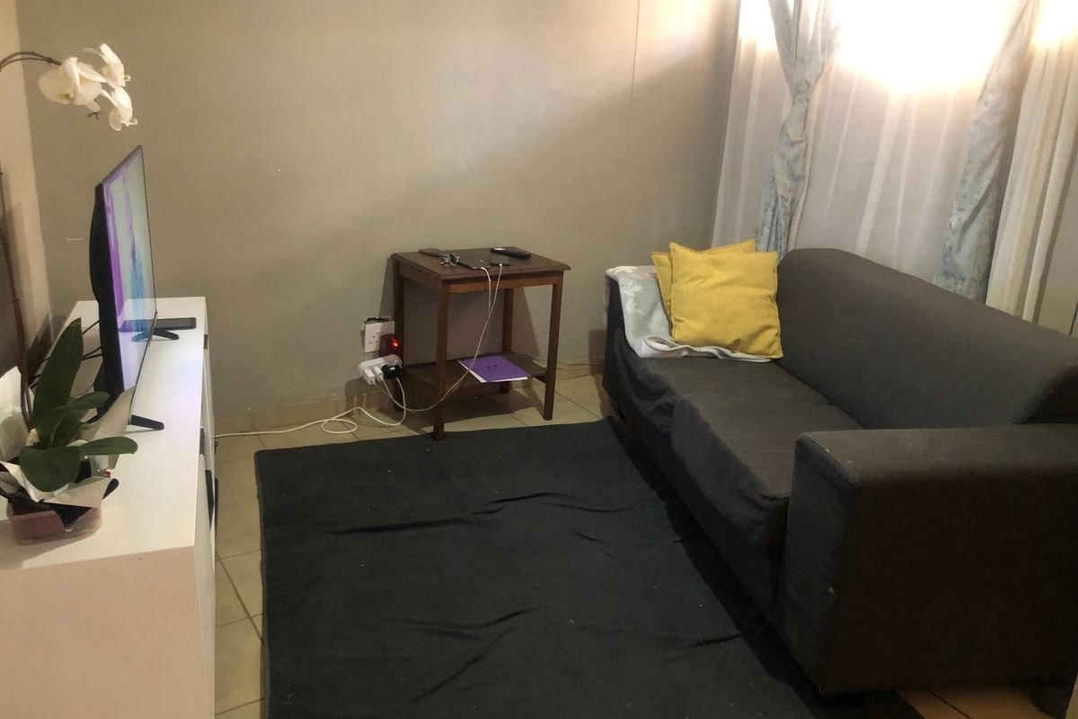 A compact living room area featuring tiled flooring and neutral wall finishes, suitable for a cozy seating arrangement.