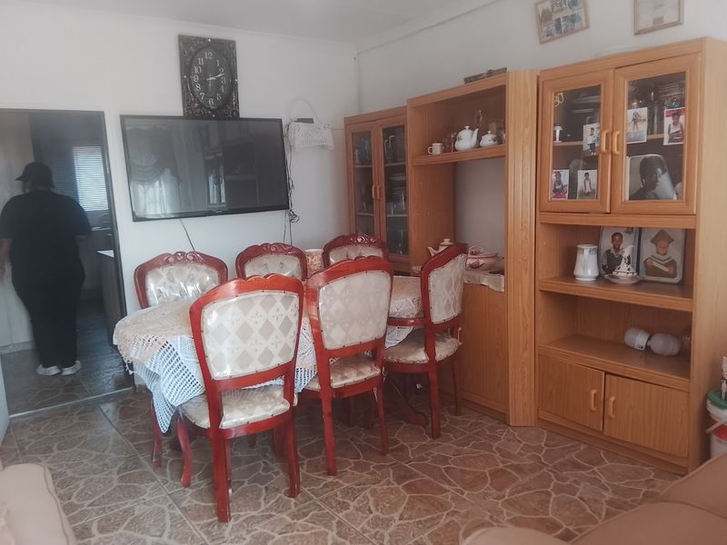 A dining room featuring tiled flooring and built-in wooden cabinetry, providing a functional space for meals and storage.