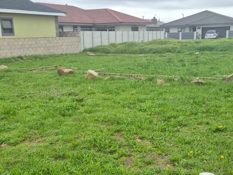 A vacant residential plot featuring a foundation slab and enclosed by precast concrete boundary walls, ready for development.