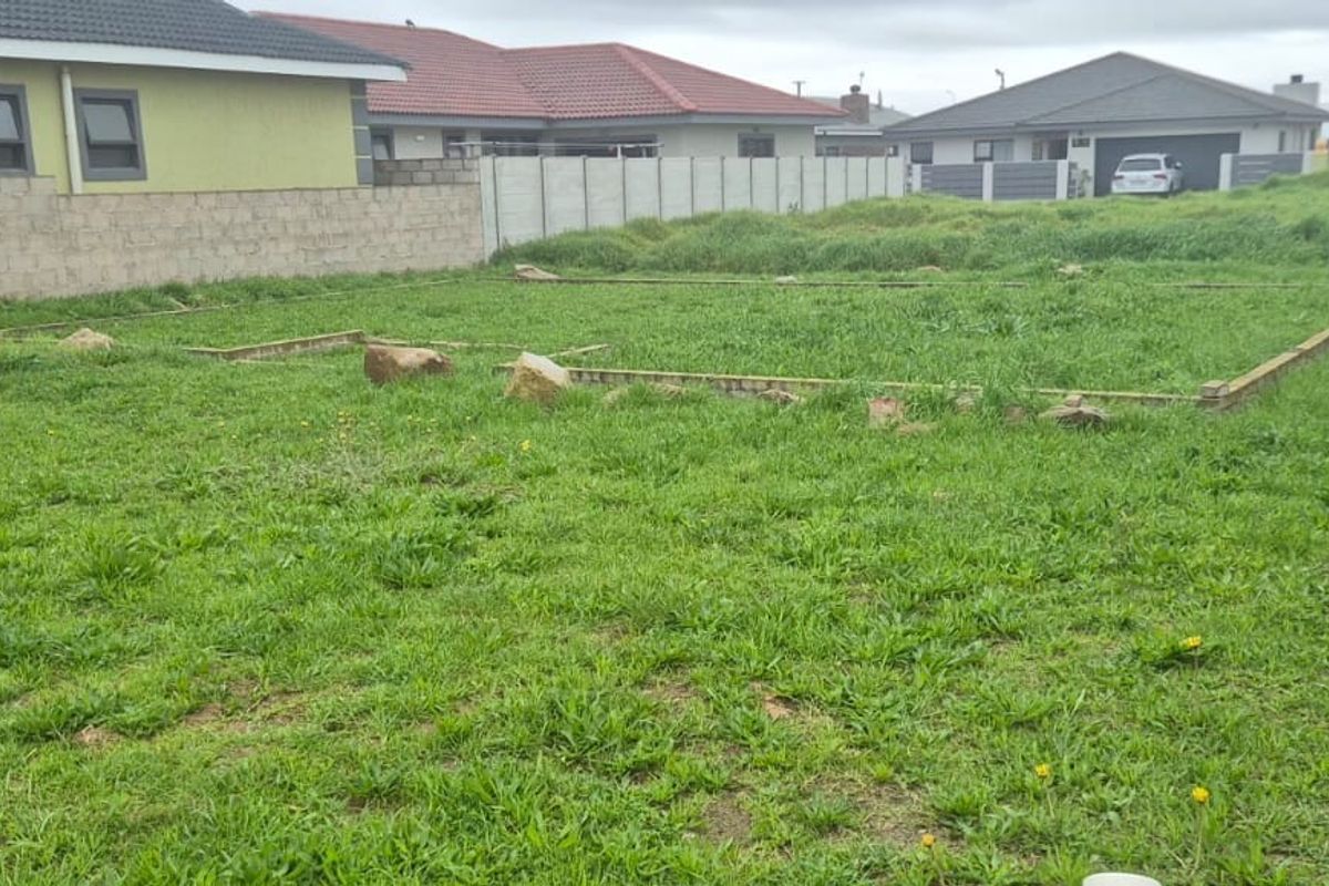 A vacant residential plot featuring a foundation slab and enclosed by precast concrete boundary walls, ready for development.