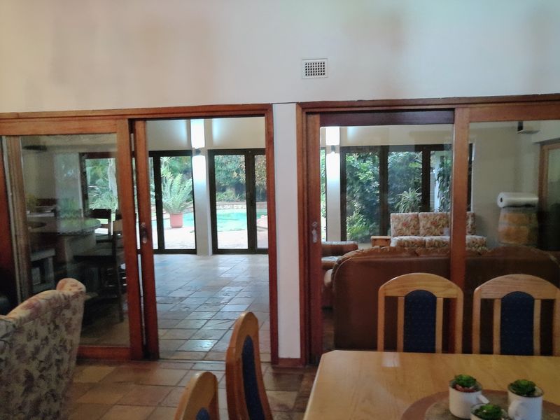 Spacious living area featuring large timber sliding doors that provide seamless access to the outdoor patio and pool area.