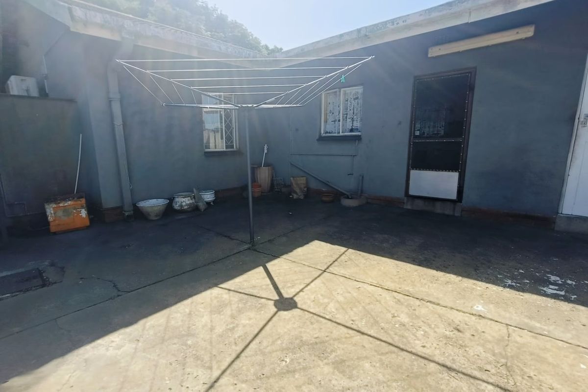 Rear courtyard area featuring concrete paving and a fixed rotary washing line, providing functional outdoor utility space.