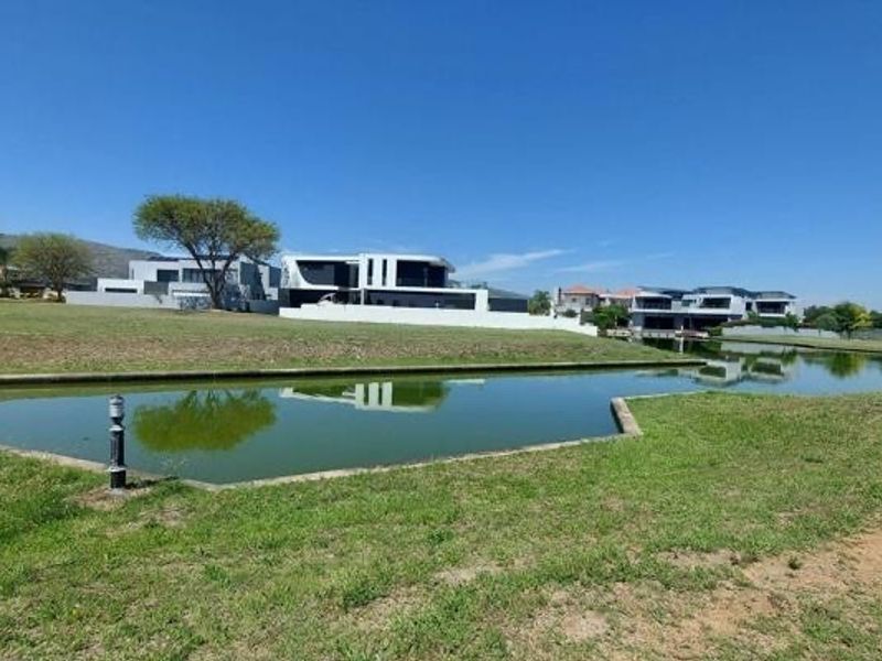 A scenic view of a residential canal and surrounding landscaped green space within a modern estate setting.