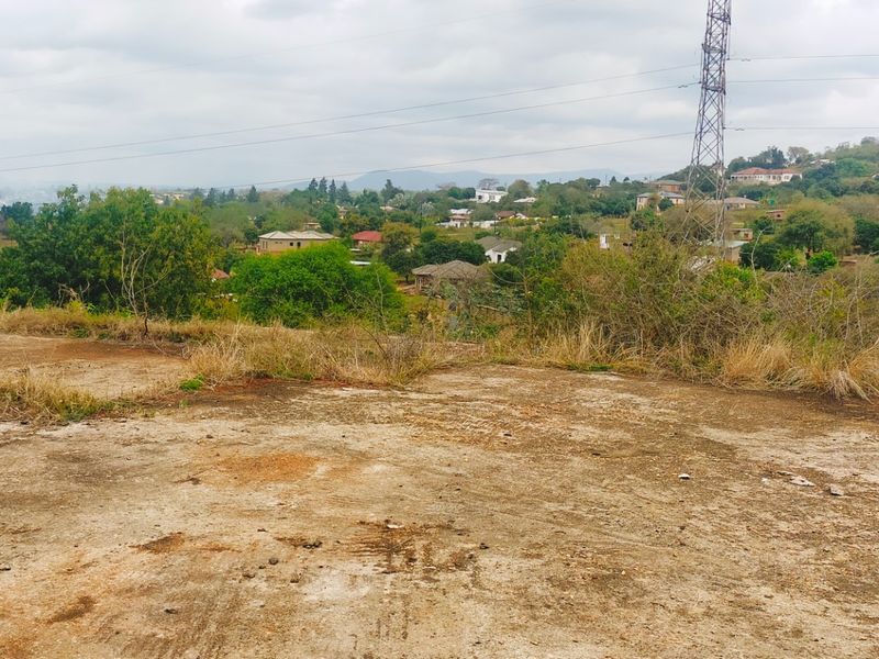 Elevated view overlooking the surrounding residential landscape and neighborhood, featuring an open, undeveloped plot in the foreground.