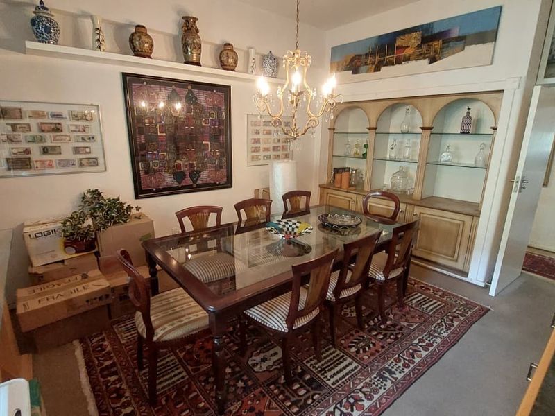 A formal dining room featuring a built-in arched display cabinet, a classic chandelier, and a floating wall shelf for decor.
