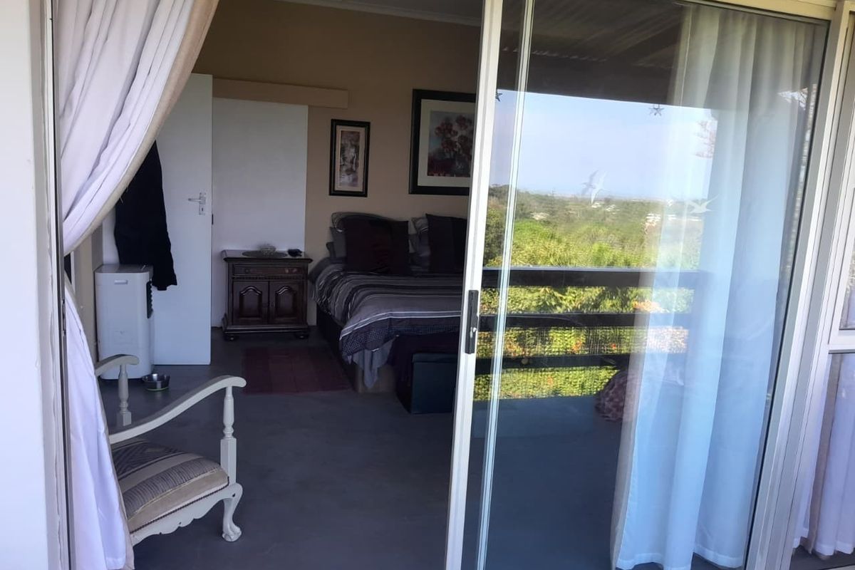 Bedroom featuring a sliding glass door that opens onto an outdoor area, providing natural light and access to the exterior.
