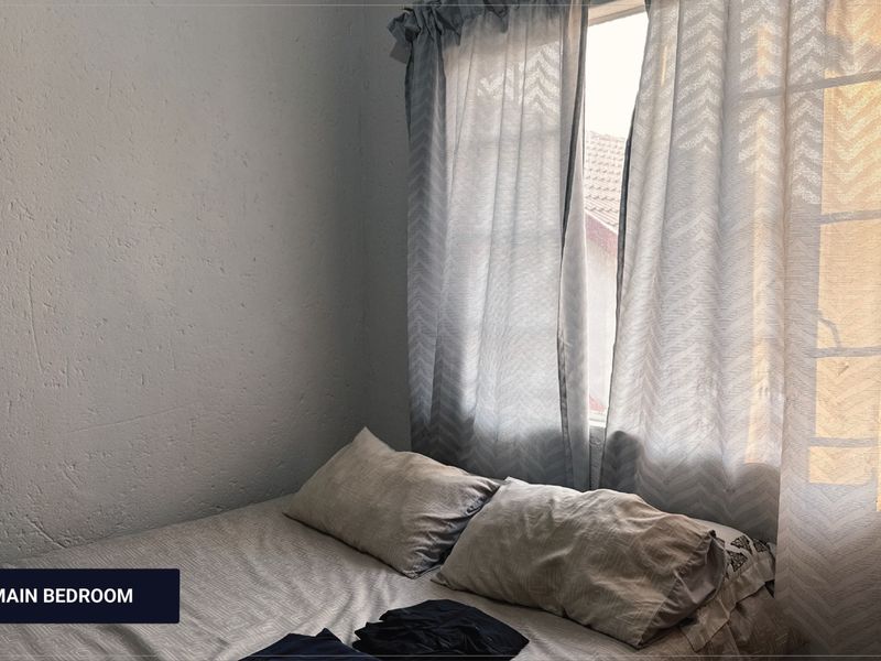A bedroom featuring a window with natural light and installed curtain rods.