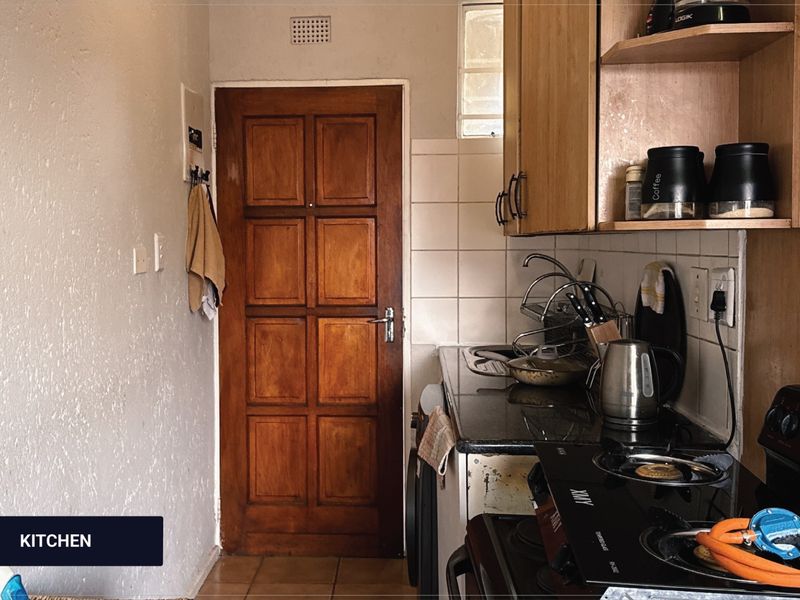 Compact kitchen featuring granite countertops, tiled backsplash, and wooden cabinetry, offering a functional layout with potential for modern cosmetic updates.