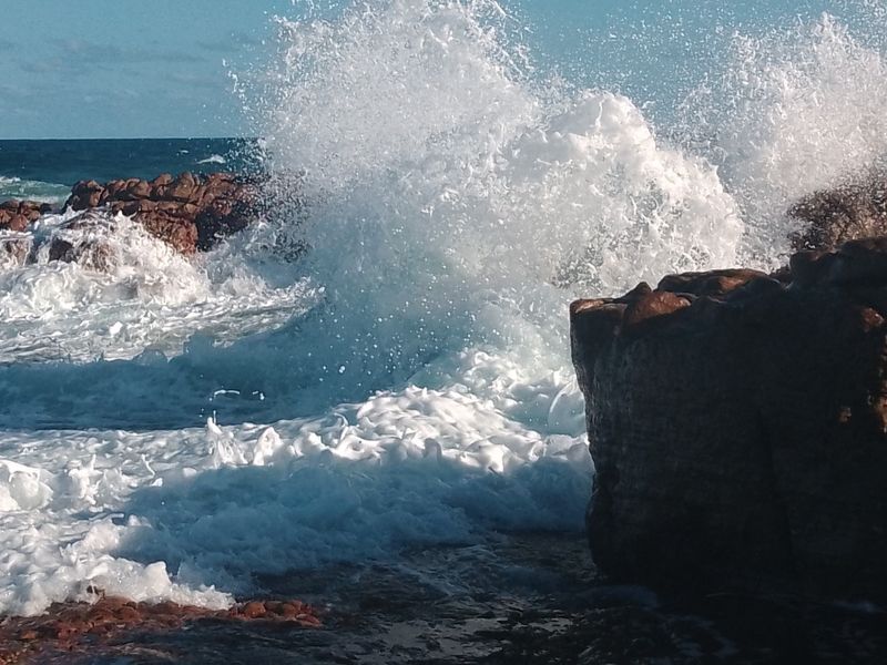 A scenic view of ocean waves crashing against rocky coastal formations.