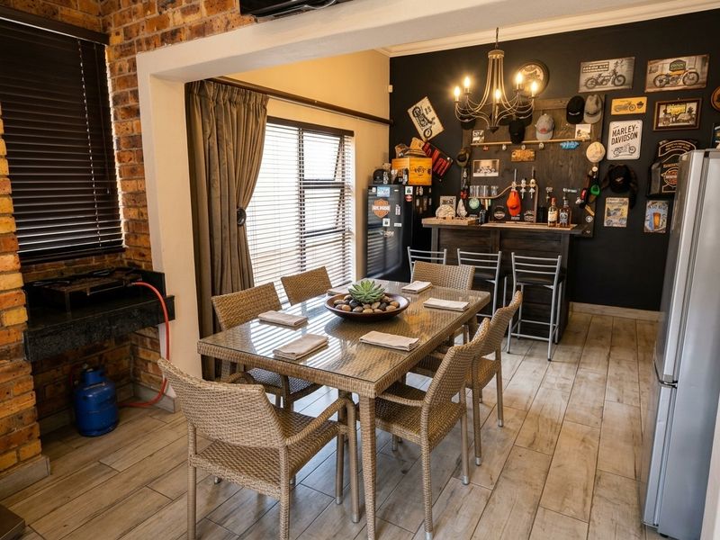 A dedicated bar area featuring a built-in counter, exposed brick wall, and integrated gas braai, perfect for entertaining.