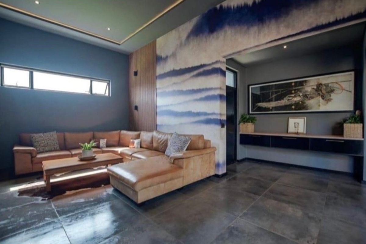Modern living room featuring high-quality tiled flooring, timber wall accents, recessed ceiling lighting, and a sleek floating cabinet unit.