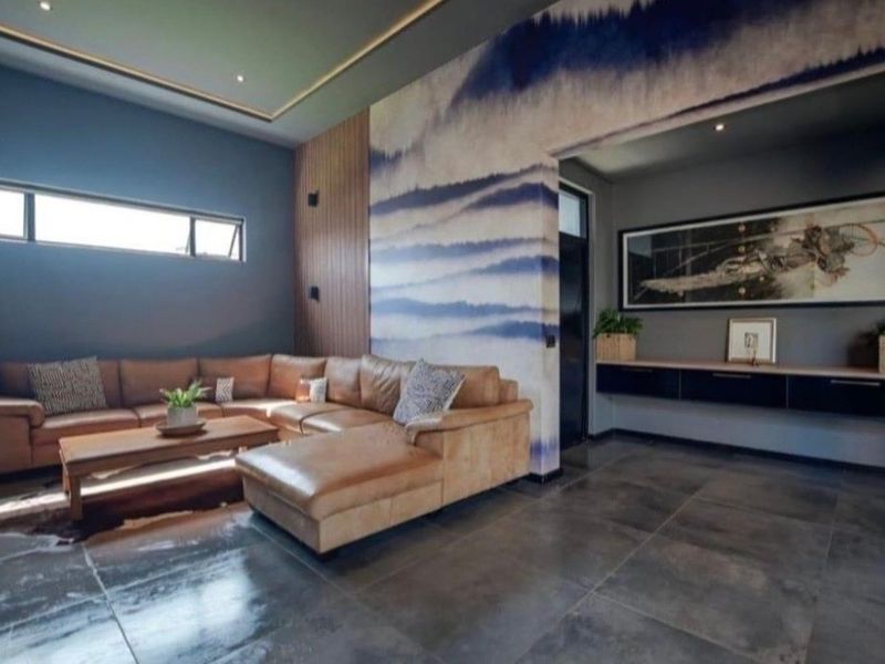 Modern living room featuring high-quality tiled flooring, timber wall accents, recessed ceiling lighting, and a sleek floating cabinet unit.