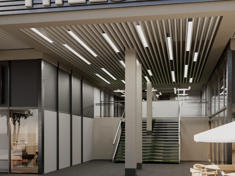 Modern commercial building entrance featuring a covered walkway, recessed lighting, and a prominent Hillside signage facade.